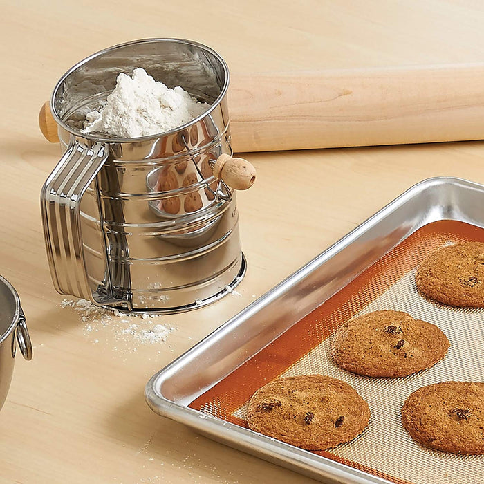 flour sifter vintage style with sifted flour near cookies