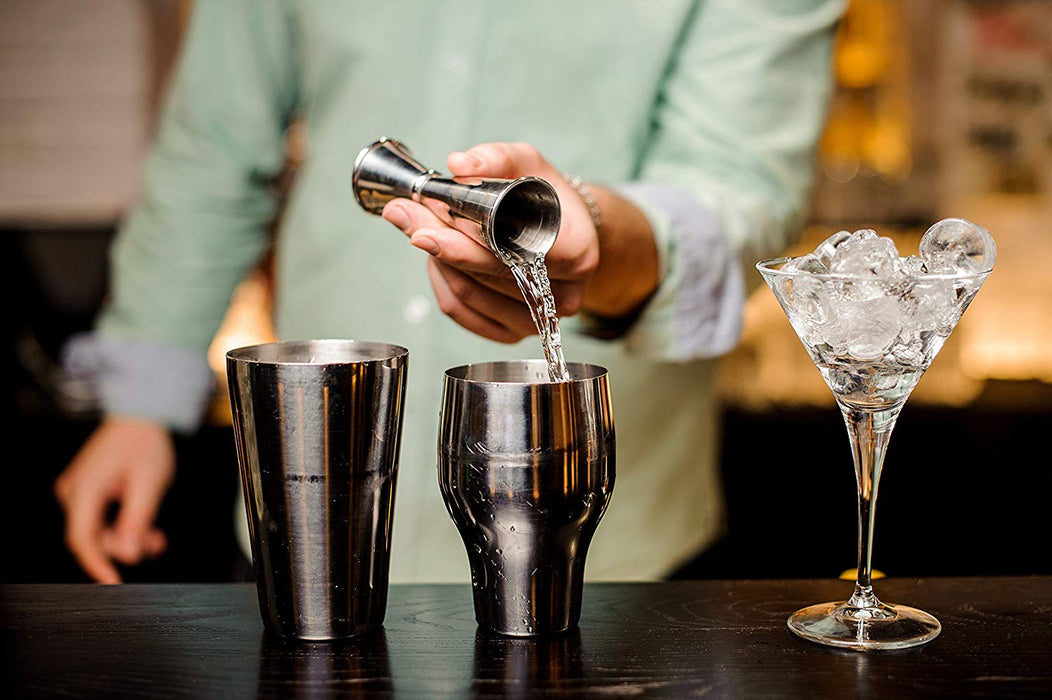 using a japanese style double jigger to prepare a cocktail in a bar