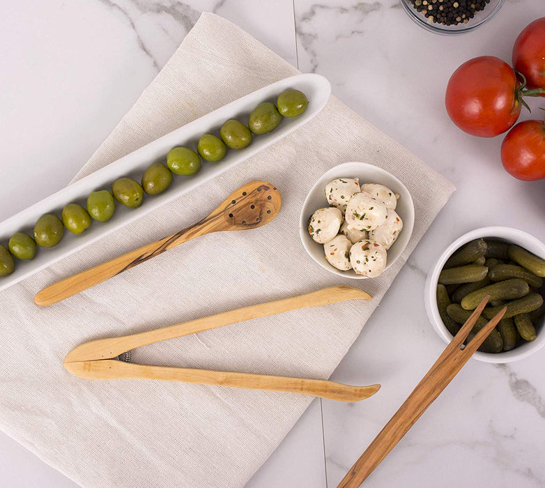 olive wood pickle fork on countertop with small pickles and olives in olive tray