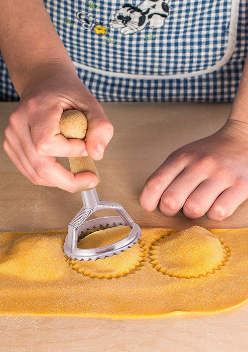 cutting ravioli with a round ravioli stamp in kitchen